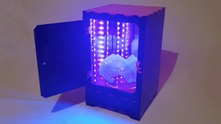 A resin 3D print being post-cured in a UV curing box