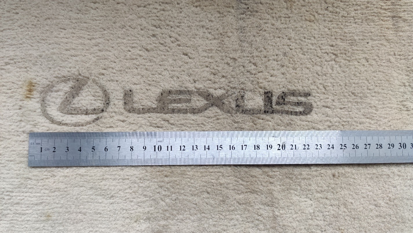 restoration of a Lexus logo on a piled car foot carpet.